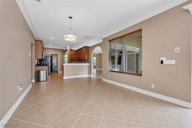 unfurnished living room with ornamental molding and light tile patterned floors