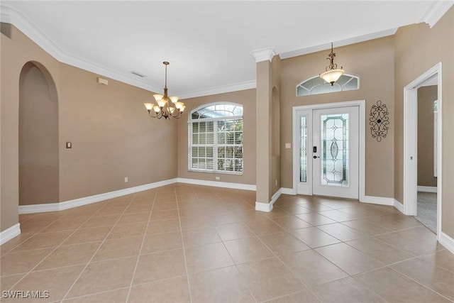 tiled foyer entrance with an inviting chandelier and ornamental molding