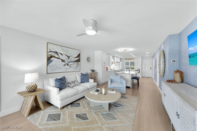 living area featuring recessed lighting, baseboards, a ceiling fan, and light wood finished floors