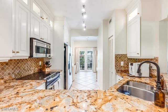871 Tanbark Dr Unit 102, Naples, FL 34108 - kitchen with appliances with stainless steel finishes, a sink, light stone counters, light tile patterned flooring, and backsplash