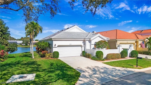 ranch-style home featuring a garage, a front lawn, and a water view