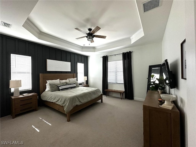 bedroom featuring ornamental molding, a tray ceiling, and visible vents