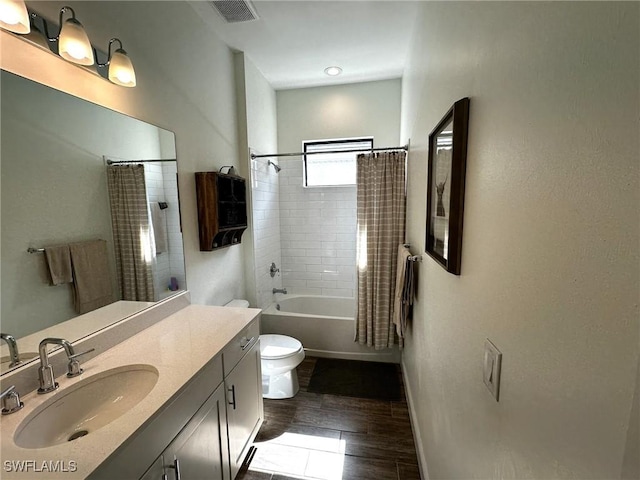 bathroom with visible vents, toilet, shower / tub combo, vanity, and baseboards