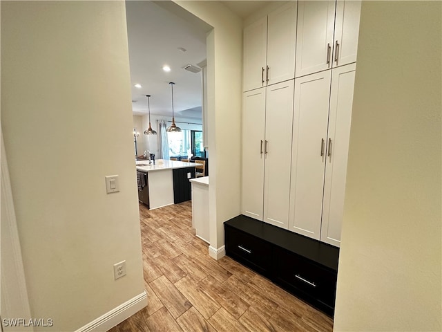 mudroom with light wood-type flooring, baseboards, visible vents, and recessed lighting