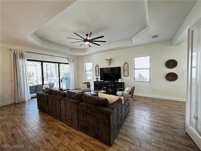 living area featuring ceiling fan, wood finish floors, visible vents, baseboards, and a raised ceiling