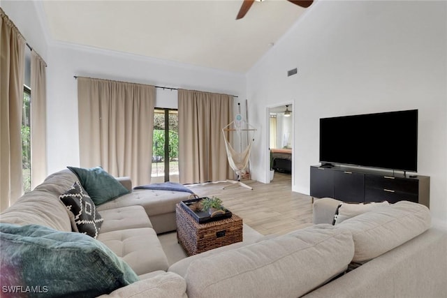 living room with ceiling fan, high vaulted ceiling, and light hardwood / wood-style flooring