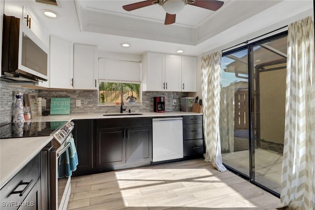 kitchen featuring stainless steel electric range oven, a tray ceiling, dishwasher, and white cabinets