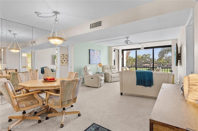 carpeted dining room featuring ceiling fan