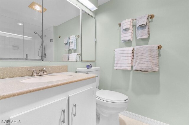 bathroom with vanity, toilet, and a shower with shower door