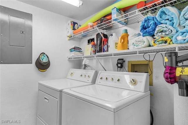 clothes washing area featuring electric panel and washing machine and dryer