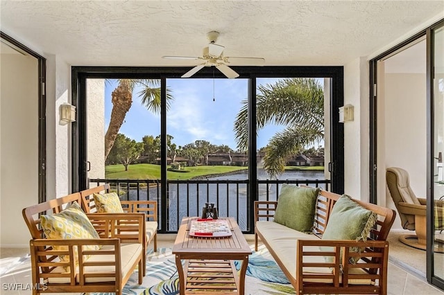 sunroom featuring a water view and ceiling fan