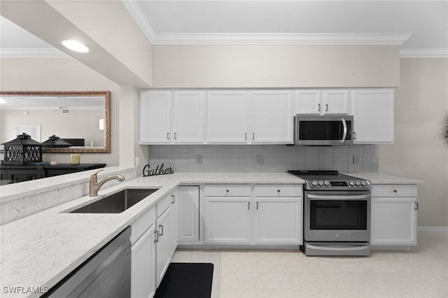 kitchen with appliances with stainless steel finishes, white cabinetry, sink, light stone counters, and crown molding