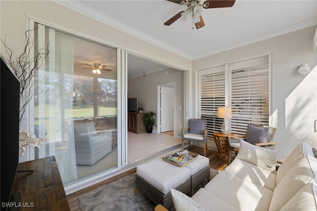 living room with crown molding, ceiling fan, and wood-type flooring