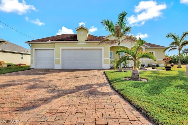 mediterranean / spanish house featuring a garage and a front yard