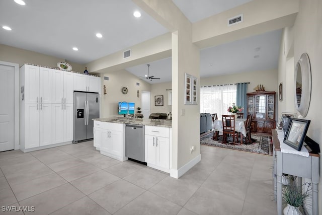 kitchen with stainless steel appliances, light stone countertops, white cabinets, and ceiling fan