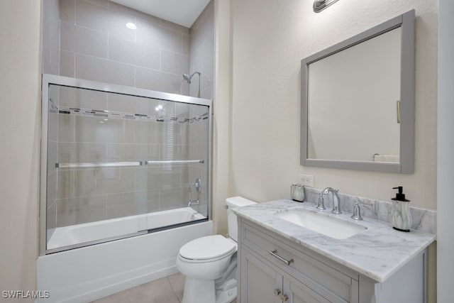 full bathroom featuring toilet, tile patterned floors, vanity, and bath / shower combo with glass door