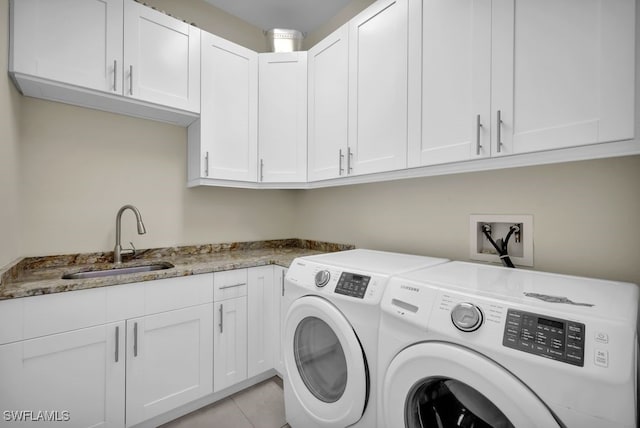 washroom featuring cabinets, sink, and washing machine and clothes dryer