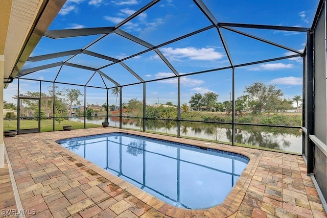 view of pool with a water view, a patio area, and glass enclosure