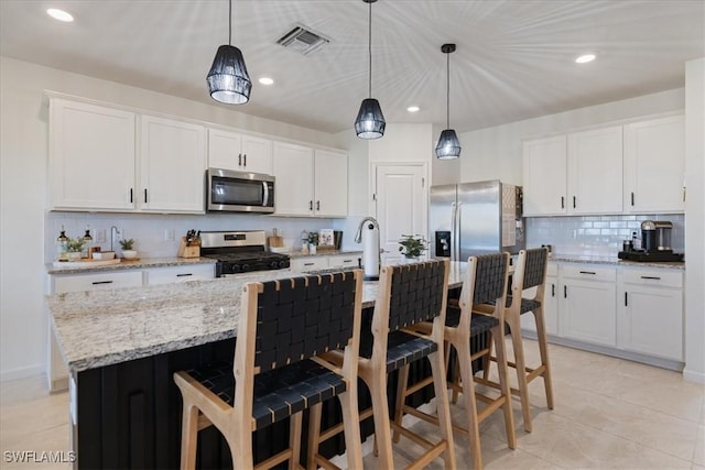 42443 Cascade Dr, Punta Gorda, FL 33982 - kitchen with stainless steel appliances, backsplash, visible vents, pendant lighting, and white cabinetry