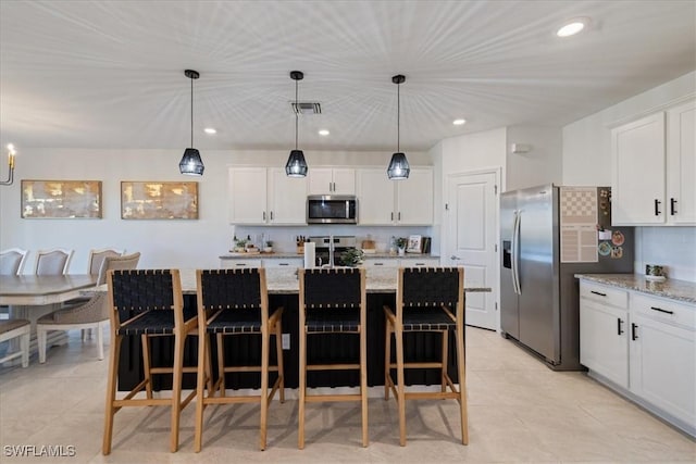 kitchen with hanging light fixtures, white cabinets, visible vents, and stainless steel appliances