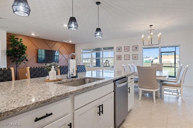 kitchen featuring white cabinetry, sink, decorative light fixtures, and stainless steel dishwasher