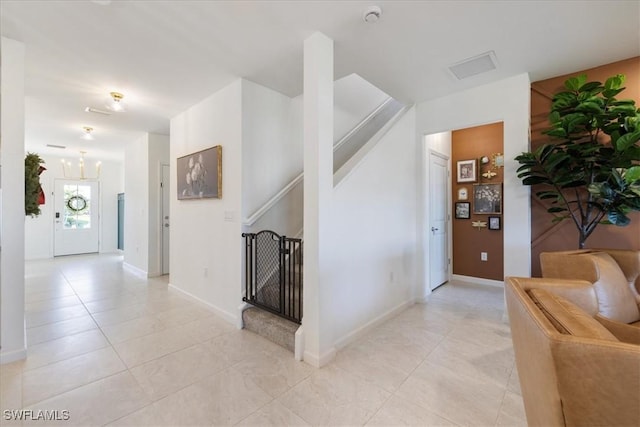 hallway featuring stairway, baseboards, and light tile patterned flooring