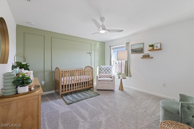 bedroom featuring ceiling fan, carpet floors, and a crib