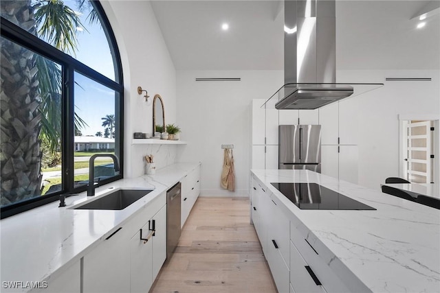 kitchen with sink, island range hood, stainless steel appliances, and white cabinets