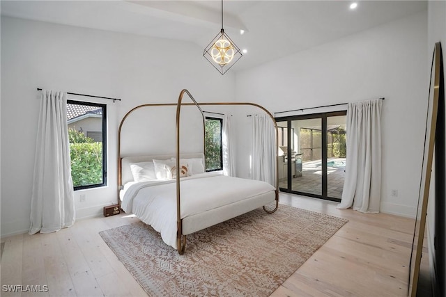 bedroom with high vaulted ceiling, access to outside, a notable chandelier, and light wood-type flooring