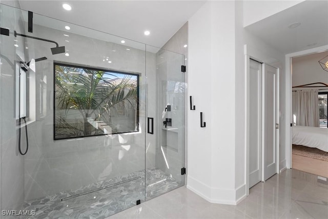 bathroom with a shower with shower door and a wealth of natural light