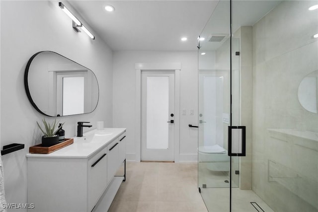 bathroom featuring tile patterned flooring, vanity, toilet, and walk in shower