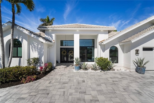 back of property with a garage and french doors