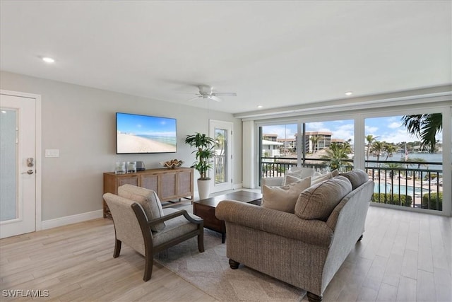 living room featuring ceiling fan and light hardwood / wood-style floors