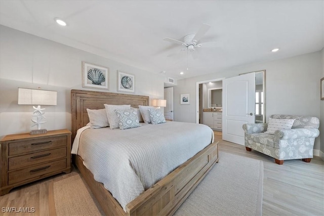 bedroom featuring ceiling fan, ensuite bathroom, and light wood-type flooring