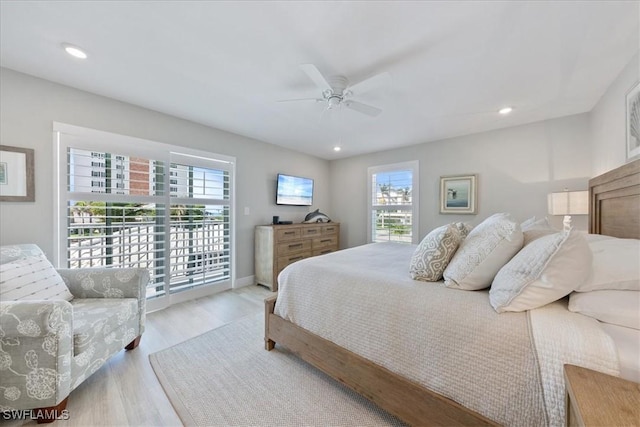 bedroom with ceiling fan, access to exterior, light hardwood / wood-style floors, and multiple windows