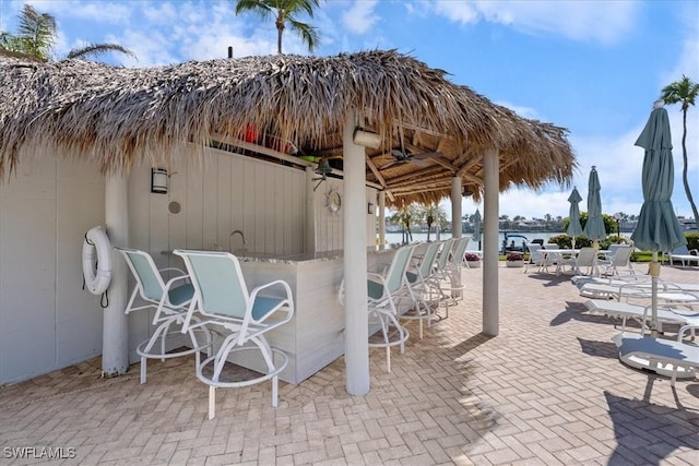 view of patio with a water view and a bar