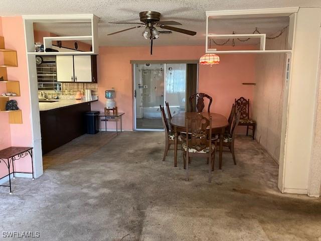 dining room with ceiling fan, a textured ceiling, and dark colored carpet