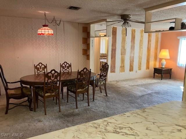 dining area with ceiling fan, carpet floors, and a textured ceiling