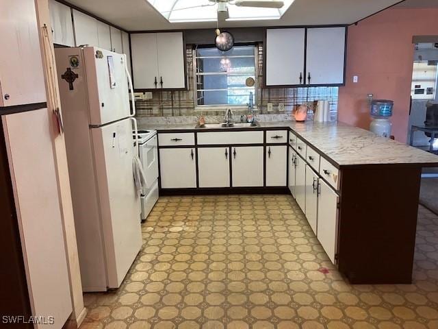 kitchen featuring sink, white appliances, backsplash, white cabinets, and kitchen peninsula