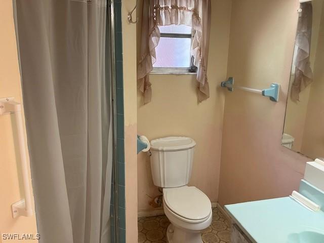 bathroom with vanity, curtained shower, and toilet