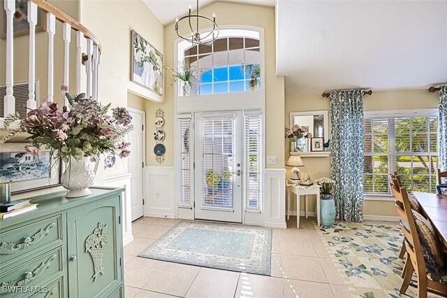 tiled foyer entrance with a notable chandelier and a high ceiling