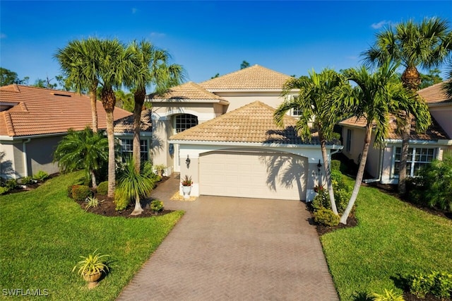 mediterranean / spanish-style home with a garage and a front lawn