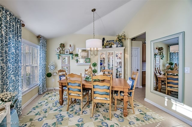 dining room featuring lofted ceiling and light tile patterned floors