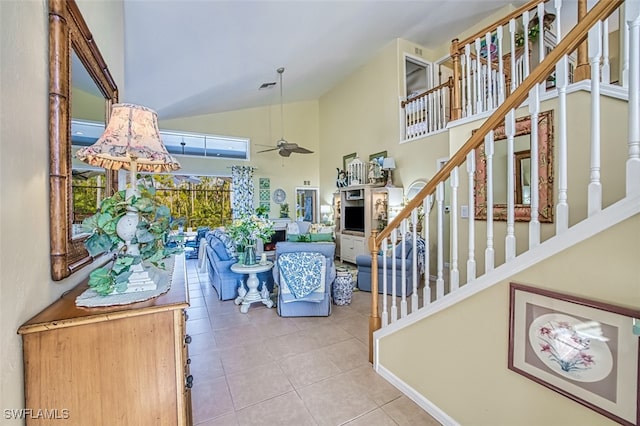 stairway with ceiling fan, tile patterned floors, and high vaulted ceiling