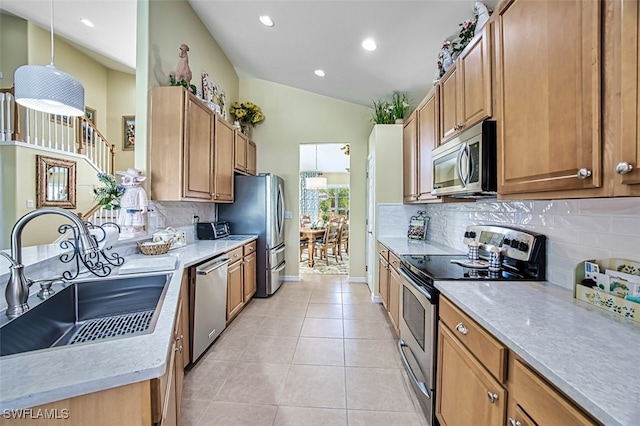 kitchen with lofted ceiling, sink, hanging light fixtures, light tile patterned floors, and appliances with stainless steel finishes