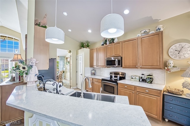 kitchen with stainless steel appliances, decorative light fixtures, sink, and plenty of natural light