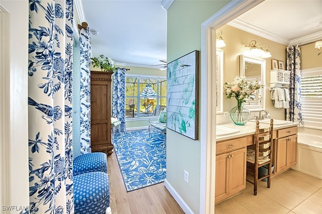 bathroom with crown molding, a bath, vanity, and ceiling fan