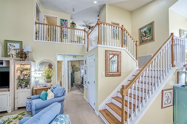 stairway featuring tile patterned floors and a high ceiling