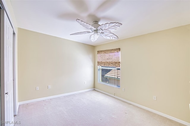 spare room with baseboards, carpet, and a ceiling fan
