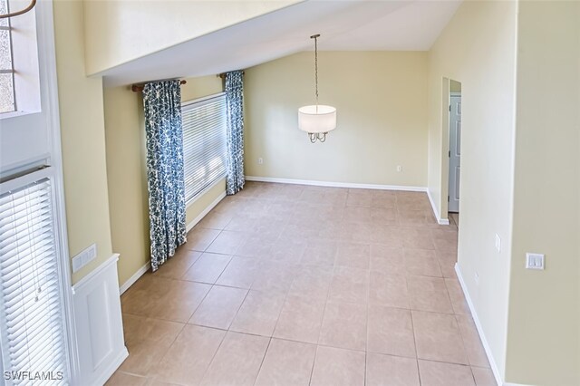 9062 Shadow Glen Way, Fort Myers, FL 33913 - empty room with lofted ceiling, light tile patterned flooring, and baseboards